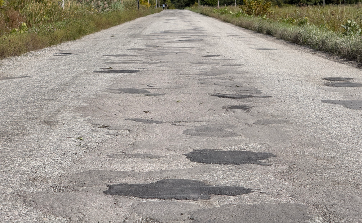 Picture of Chemin Kelly with many asphalt-filled pot holes